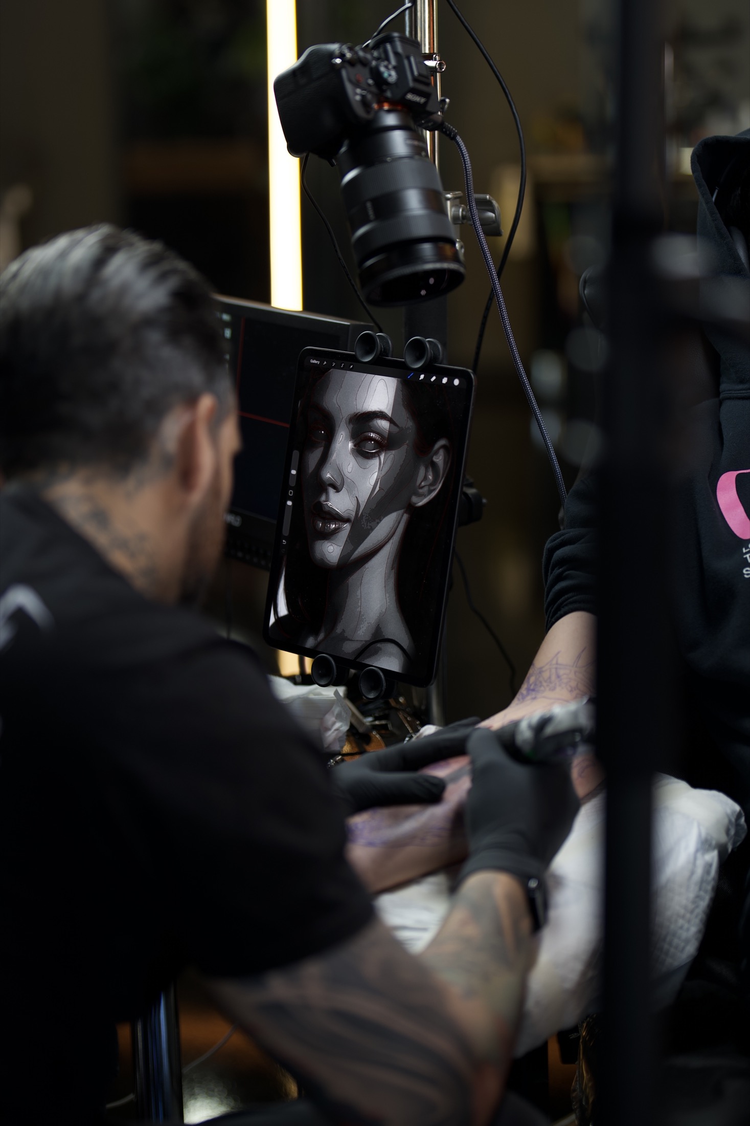 Camera and tablet setup used to record a dark realism tattoo session.